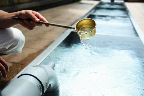 a person is pouring water into a fountain at Tanakaya in Kurobe