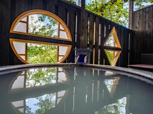 an empty swimming pool with a wooden fence and a circular window at Nagominoyado Hanagokoro - Reopening in Mar 2024 in Hakone