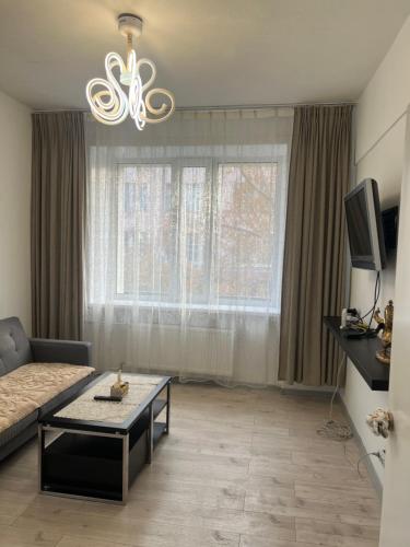 a living room with a couch and a chandelier at Brilliant location 3 in Ulaanbaatar
