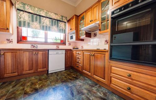 a kitchen with wooden cabinets and a large microwave at Fitzroy Motor Inn in Grafton
