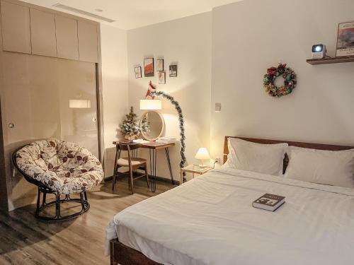 a bedroom with a bed and a chair and a table at Apartment 1BR-FL24th-R105 Building-Vinhomes Ocean Park in Hanoi