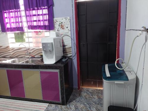 une salle de bain avec un lavabo et une poubelle dans l'établissement Jerai Geopark Cottage Song Song, à Kampong Permatang Serentang