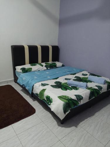 - une chambre avec un lit et une couette verte et blanche dans l'établissement Jerai Geopark Cottage Song Song, à Kampong Permatang Serentang