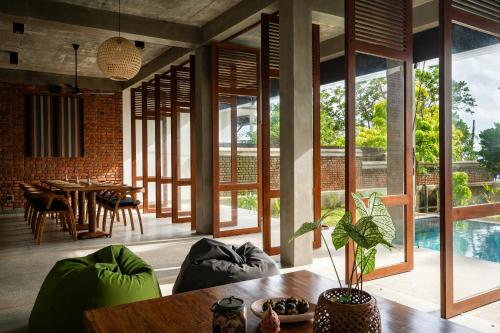 a living room with a table and some windows at Soorya Kala in Hikkaduwa