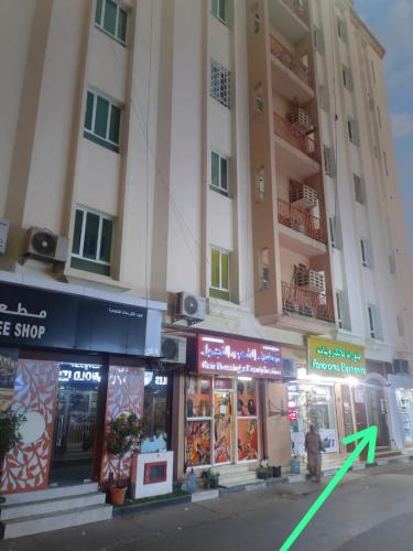 a person standing in front of a tall building at AL SHAMS MUSCAT MALE hostel in Muscat