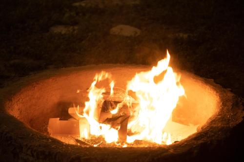 a fire pit with a person sitting in it at Maatidera Resort Kanatal The Boutique stay in the Lap of Himalayas in Kanatal