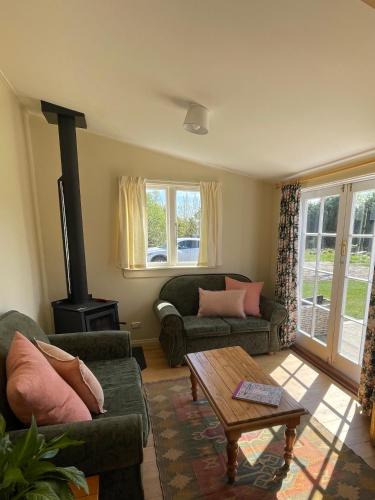a living room with two couches and a wood stove at Eden Cottage, Wedderburn in Wedderburn