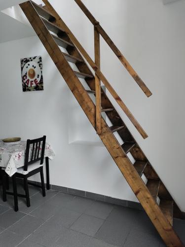 - un escalier en bois dans une chambre avec une chaise dans l'établissement Studio en duplex, à Metz