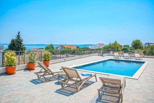 a pool with chaise lounge chairs and a swimming pool at Villa J&J in Kastel Novi
