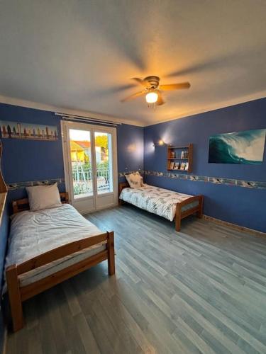 une chambre avec deux lits et un ventilateur de plafond dans l'établissement Maison 3 chambres 1km de plage, à Six-Fours-les-Plages