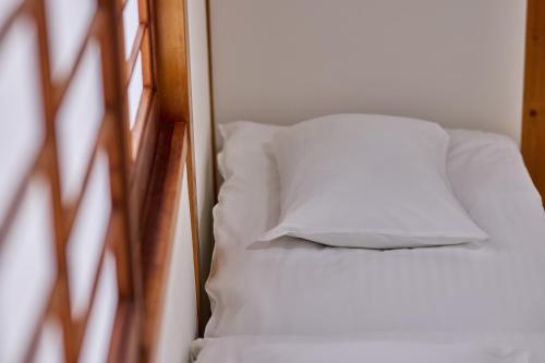 a white pillow sitting on top of a bed at Fuji Holiday in Fujiyoshida
