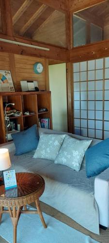 a bed with blue pillows and a table in a room at Minpaku Yururi in Yakushima