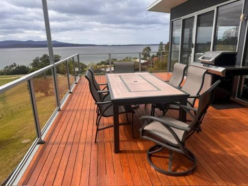 a deck with a table and chairs on a balcony at 4 Scenic Court in Mallacoota