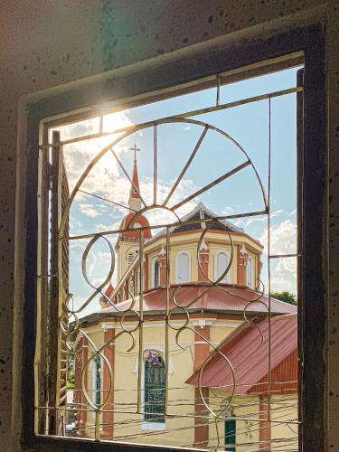 a view of a building through a window at DƯỚI TÁN CÂY homestay in Tây Ninh