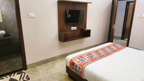 a bedroom with a bed and a tv on a wall at Hotel Delite in Bikaner