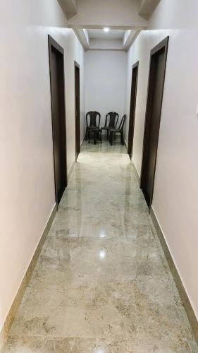 an empty corridor with chairs in a white room at Hotel Delite in Bikaner