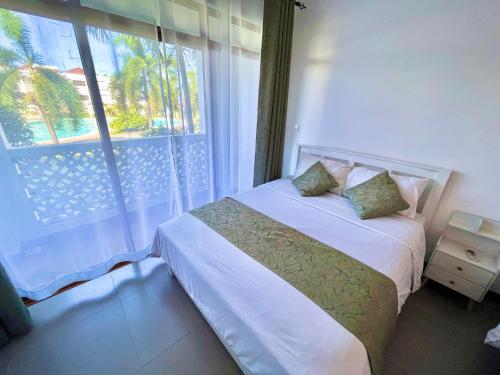 a bedroom with a bed and a large window at Bahari Haven TWO Bedroom Kikambala in Kilifi