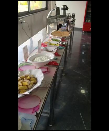 a row of tables with plates of food on them at SKD RESORT AND CLUB in Barvāla