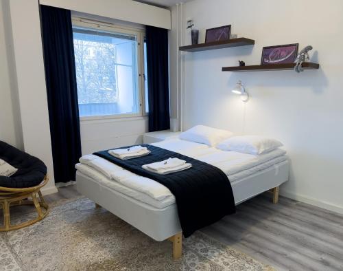 a bedroom with a bed with towels on it at Cozy 1BR City Centre Home with Free Parking in Kuopio