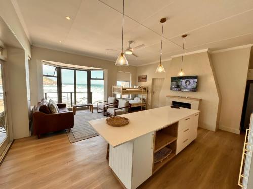 an open kitchen and living room with a view of the ocean at Oppiesee Selfcatering Apartments in Herolds Bay