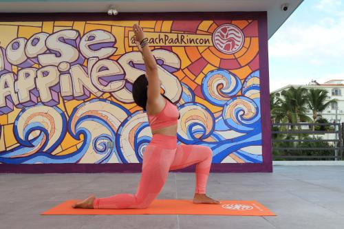 a woman doing a yoga pose in front of a wall at The Beach Pad Puntas in Rincon