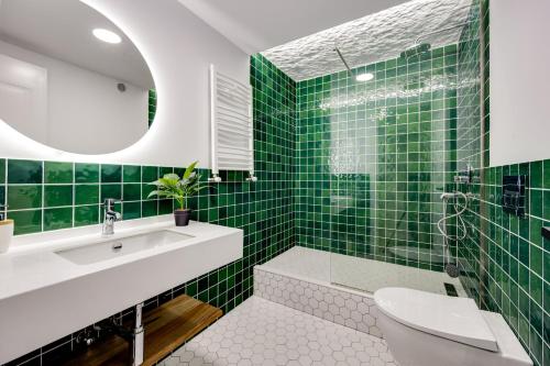 a green tiled bathroom with a toilet and a sink at Old Town Panorama View in Tbilisi City