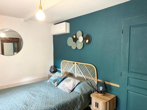 une chambre avec un lit et un mur bleu dans l'établissement Villa LEONA CLIM PARK, à Bollène