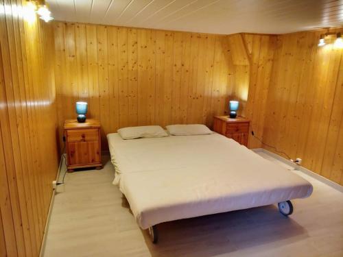 a bedroom with a bed and two night stands at Un spacieux et confortable châlet in Châtel-Saint-Denis