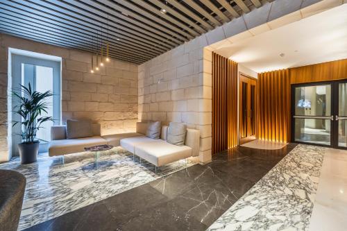 a living room with a couch and a table at The Signature Suite in Mercury Tower in St. Julianʼs