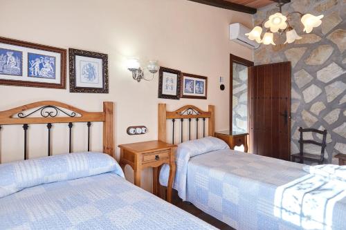 a bedroom with two beds and a chandelier at La Acacia in Martos