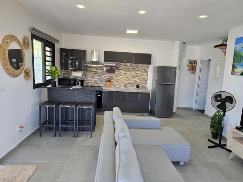 a living room with a couch and a kitchen at Fare Kenzo 2 in Papara