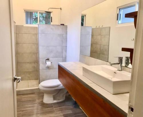 a bathroom with a white sink and a toilet at Casa Cucula - is awesome! Walk to the surf in Pavones