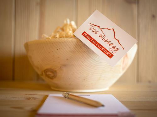 a notebook and a pen on a table with a bowl at Das Wiesegg in Fügenberg