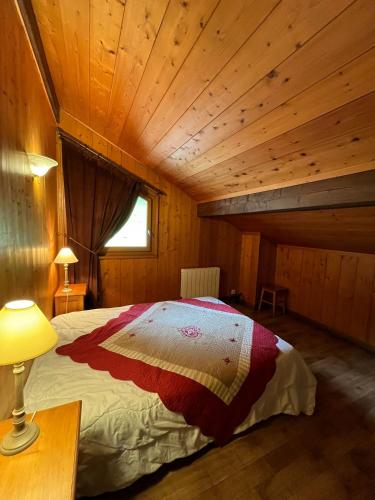 une chambre avec un lit dans une cabane en bois dans l'établissement Beau chalet proche centre/pistes - Garage - Wifi, à Morzine