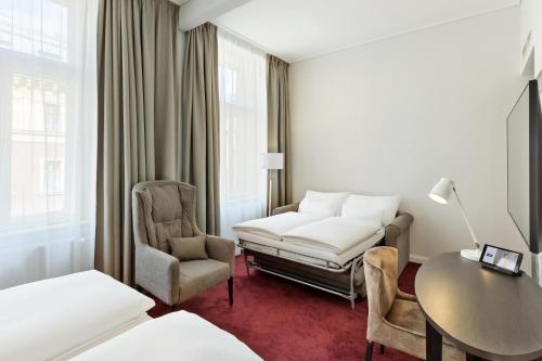a hotel room with a bed and a desk and chair at Hotel Rathauspark Wien, a member of Radisson Individuals in Vienna