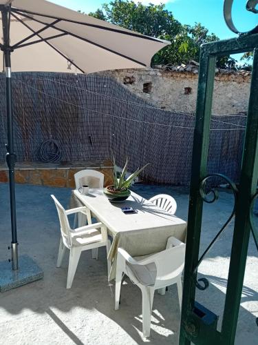 a white table and chairs under an umbrella at Angel's House in Volímai