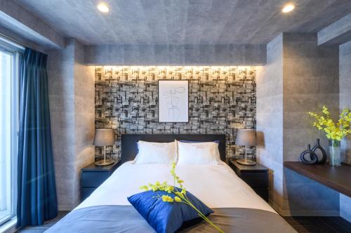 a bedroom with a large bed with two night stands at RAKU Hotel Tokyo Bay Front in Tokyo
