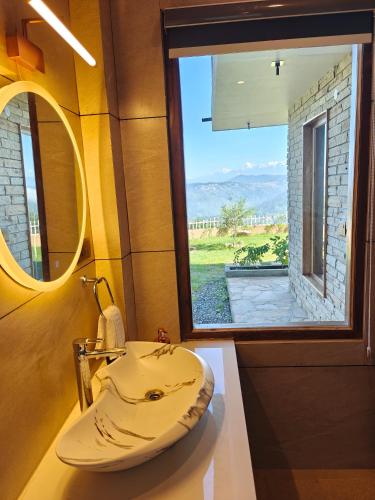 a bathroom with a sink and a large window at The Himalayan Stone Hamlet in Mukteshwar