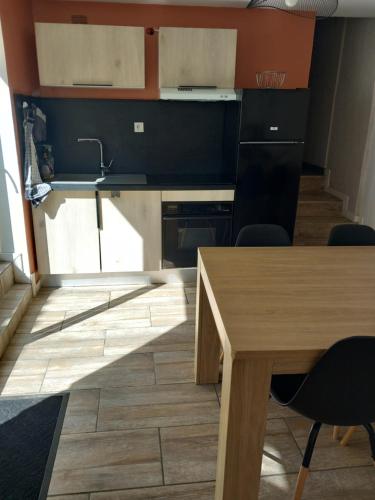 - une cuisine avec une table en bois et un évier dans l'établissement Gîte familial, à Saint-Jacques-de-Thouars