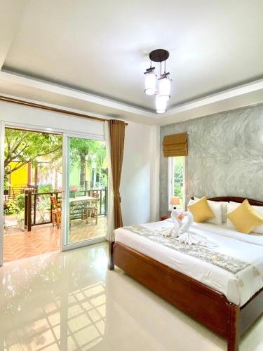 a bedroom with a bed and a sliding glass door at Lanta Just Come Bungalow in Ko Lanta
