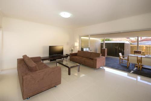 a living room with two couches and a television at 6P - Large Premium Rooms in Shared Space in Brunswick! in Melbourne