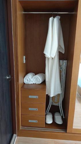 a closet with white towels and a dresser at Coco Residence, Si Saket in Khun Han