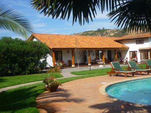 a house with a swimming pool in front of a house at Hotel Boutique Solaz Bella Vista de Colchagua in Santa Cruz