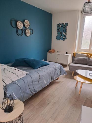 une chambre avec un lit et un mur bleu dans l'établissement Studio Dinard, à Dinard