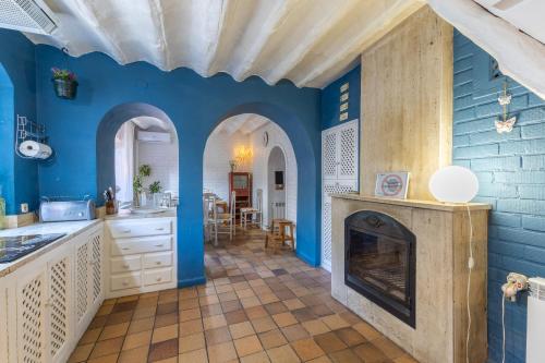 a kitchen with blue walls and a fireplace at Villa Florita in Valdelaguna