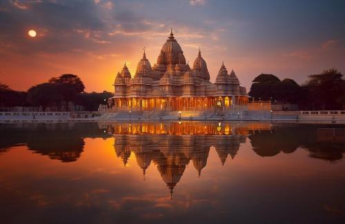 a large building with its reflection in the water at Country Inn Ayodhya - opposite airport in Ayodhya