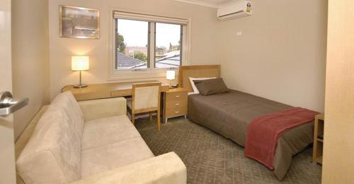 a hotel room with a bed and a desk and a couch at 6P - Large Premium Rooms in Shared Space in Brunswick! in Melbourne