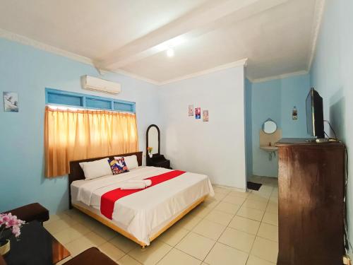 Un dormitorio con una cama y un televisor. en YUTAKA INN Araya Malang, en Blimbing
