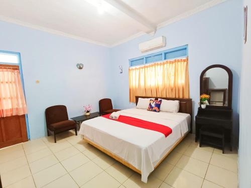 a bedroom with a bed and a table and chairs at YUTAKA INN Araya Malang in Blimbing