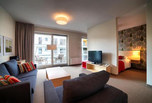 a living room with a couch and a bed at Golden Tulip Międzyzdroje Residence in Międzyzdroje